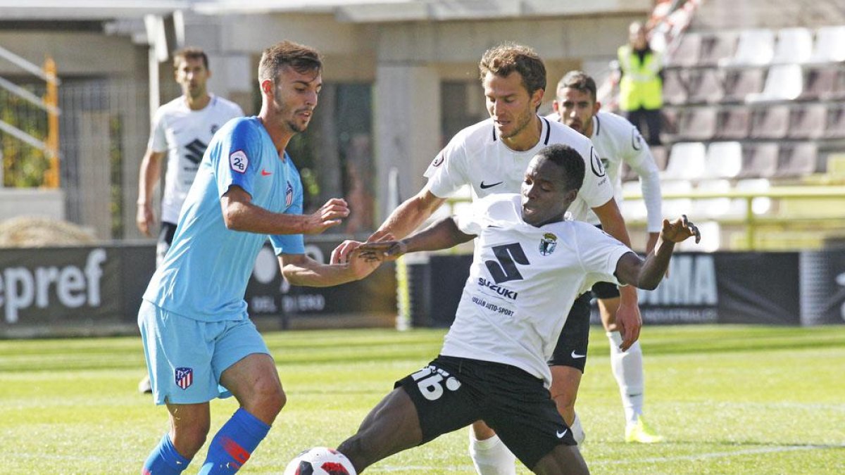 Yaw corta un balón en el choque ante el Atlético B en presencia de Jagoba Beobide.-SANTI OTERO