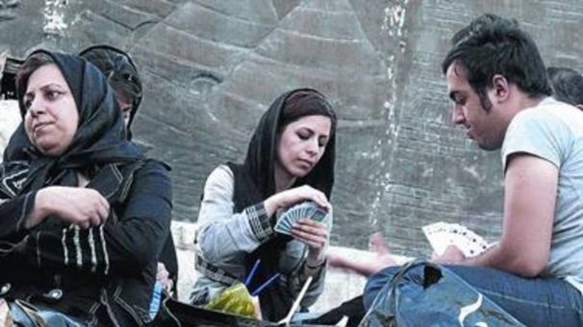 De picnic. Unos jóvenes iranís juegan a las cartas ¿pese a que está prohibido¿ en un parque de Teherán.-Foto: AFP /ATTA KENARE