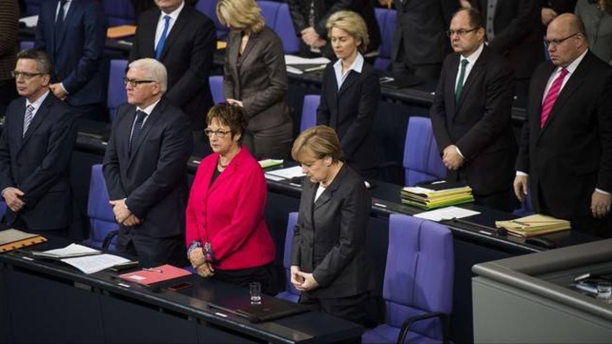 Merkel (derecha) y varios ministros guardan un minuto de silencio por las víctimas de Francia, en el Bundestag, este jueves.-Foto: AFP / ODD ANDERSEN