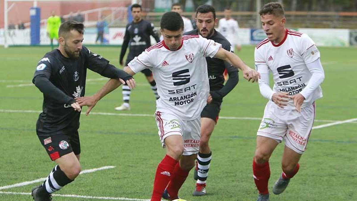 Manzano conduce un balón perseguido por un defensor del Zamora CF en el choque de ayer en San Amaro-Raúl G. Ochoa