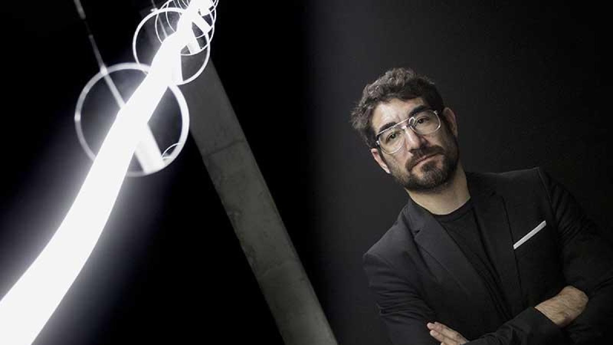 Solimán López posa al lado de la pieza de luz que materializa la estela dejada por un globo sonda lanzado al espacio hasta que se perdió su pista.-SANTI OTERO