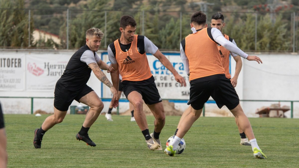 Claudio conduce el balón ante la presión de Juanma en un entrenamiento durante la concentración en Extremadura. BURGOS CF