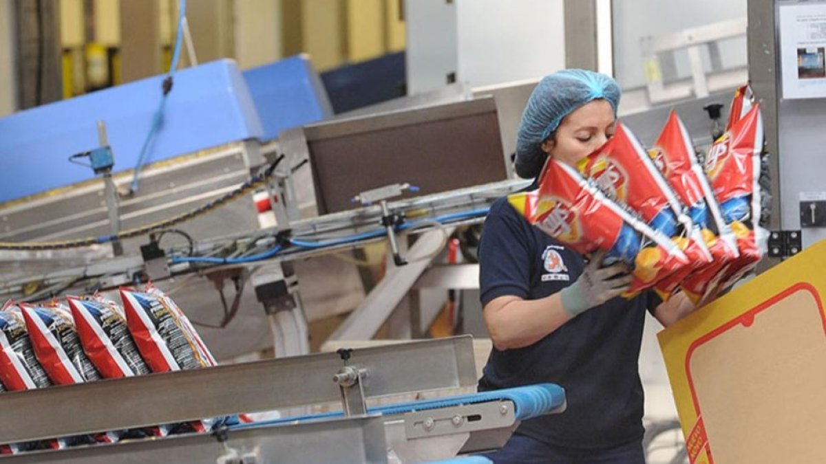 Una empleada realiza su trabajo en la línea de producción de una fábrica burgalesa de snacks.