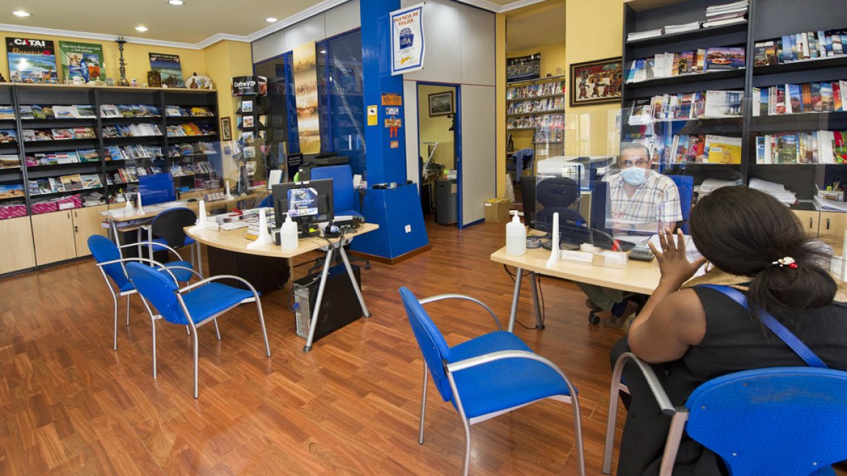 Un agente de viajes atiende a una clienta. ISRAEL. MURILLO