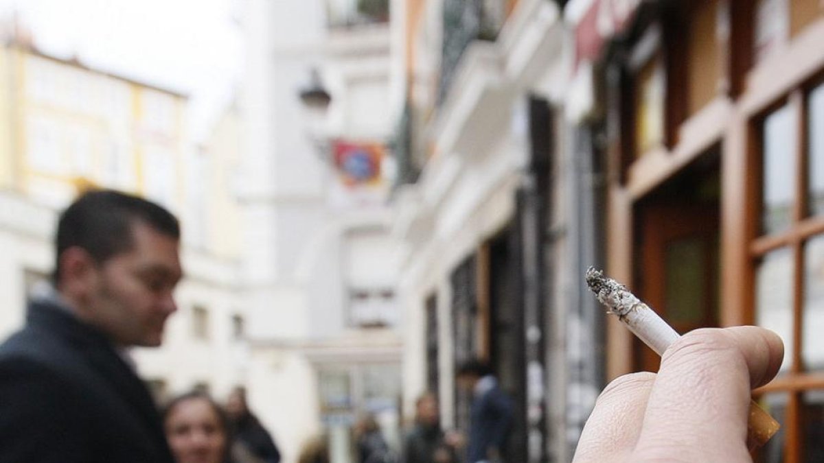 Personas fumando en la vía pública. Cada vez son más los que dejan el hábito.-R. O.