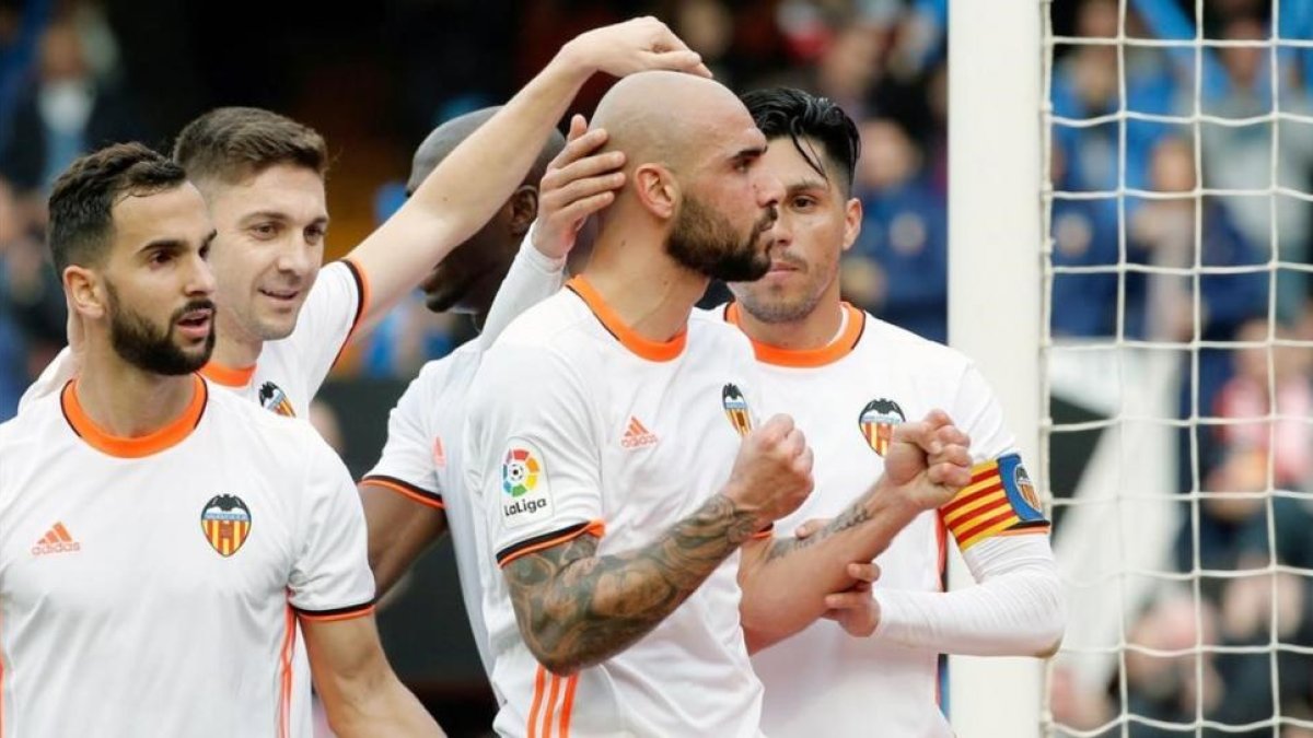 Los jugadores del Valencia felicitan a Simone Zaza tras marcarle el segundo gol al Athletic en Mestalla.-EFE / JUAN CARLOS CÁRDENAS