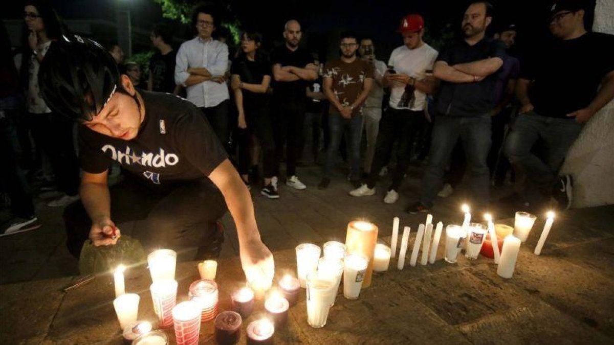 Familiares y amigos de los tres estudiantes asesinados durante una vigilia frente a la casa del gobernador del estado de Jalisco el 23 de abril.-ULISES RUIZ (AFP)