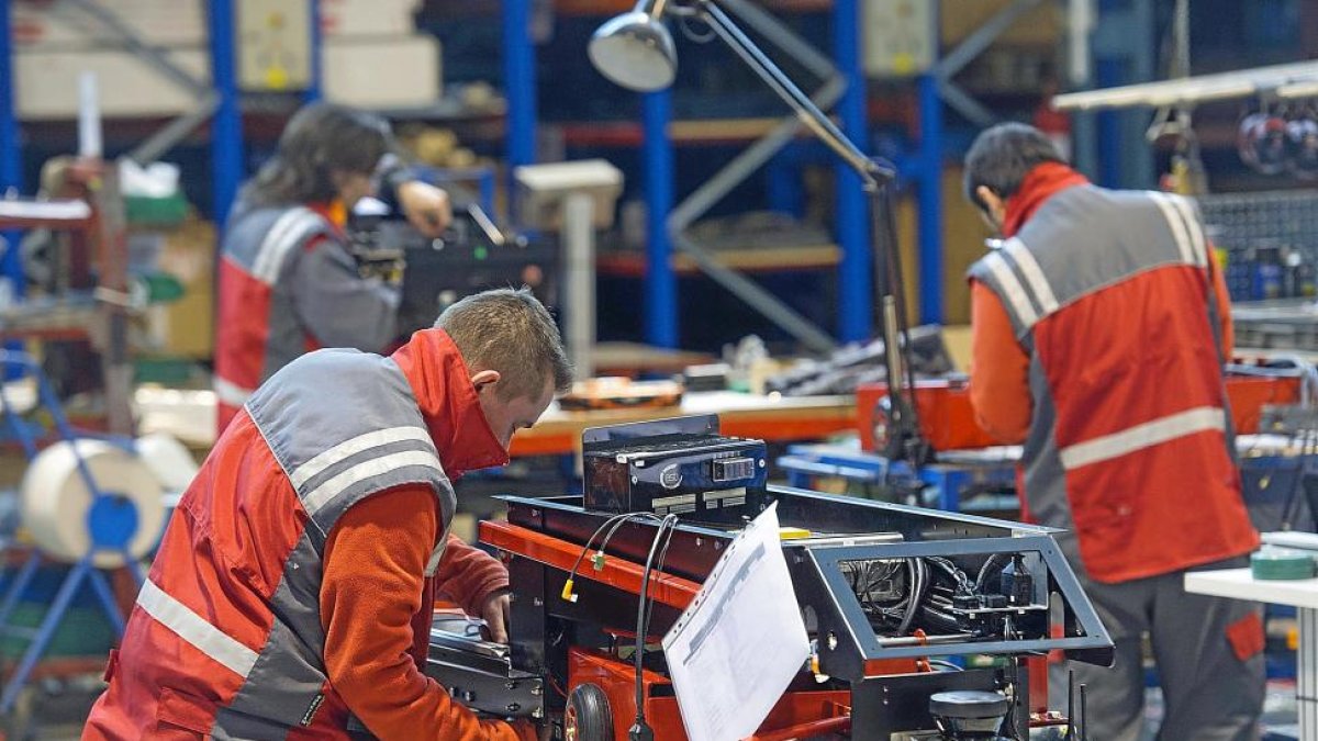 Dos trabajadores de la empresa  Asti fabrican un vehículo de guiado automático.-ISRAEL L. MURILLO