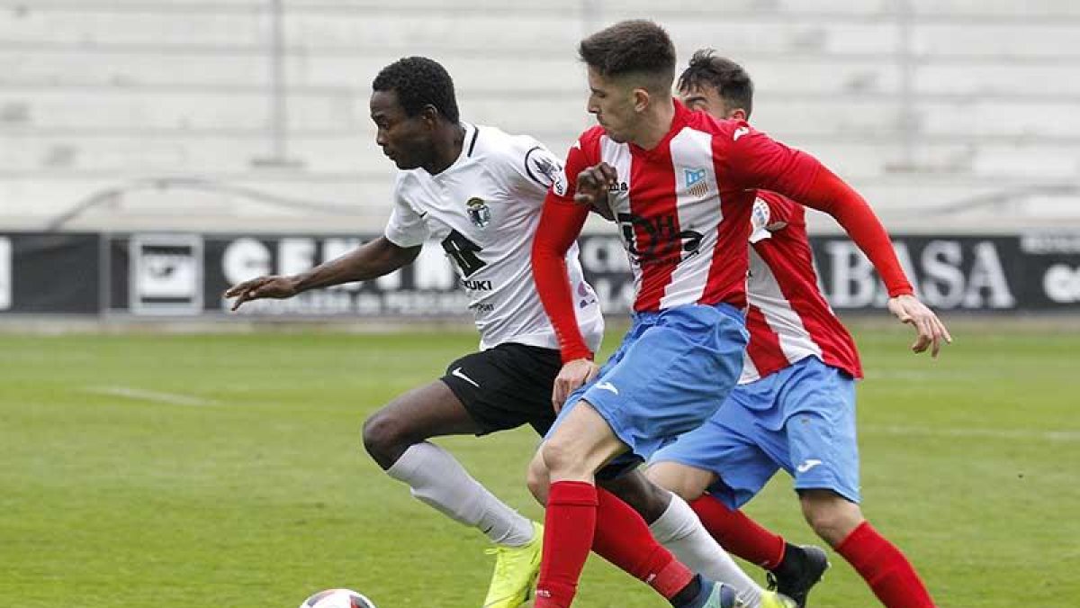 Yaw Annor trata de escaparse en velocidad del marcaje de dos jugadores del Navalcarnero-Santi Otero