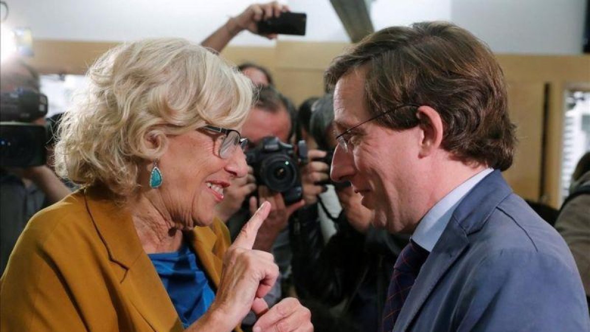 La alcaldesa de Madrid en funciones Manuela Carmena conversa con el candidato a la alcaldía por el PP Jose Luis Martinez-Almeida, durante el último Pleno de esta legislatura.-EFE