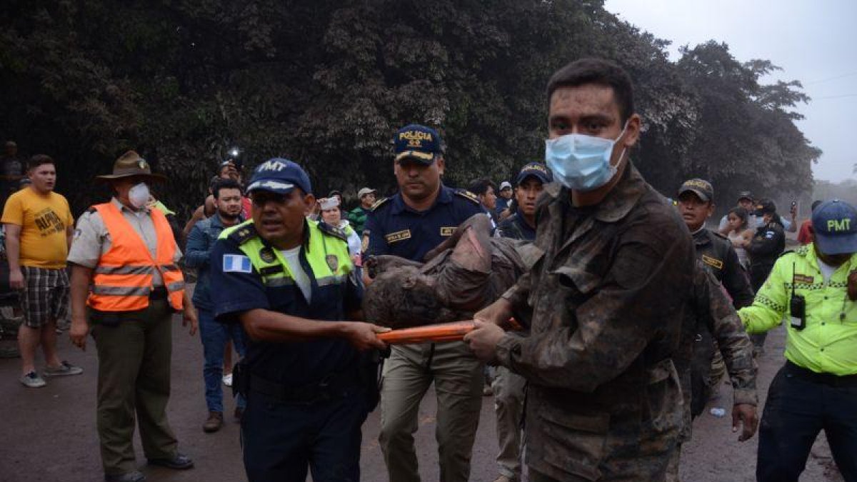 Los equipos de rescate trasladan a un herido tras la erupción del volcán de Fuego, en el municipio de El Rodeo, prácticamente arrasado.-NOE PÉREZ (EFE)