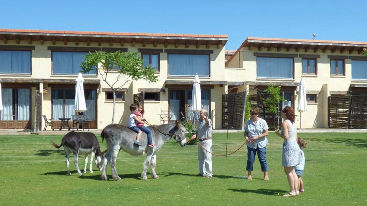 Dos niños dan un paseo en burro en un alojamiento rural de la provincia burgalDos niños dan un paseo en burro en un alojamiento rural de la provincia burgalesa.esa.-ECB