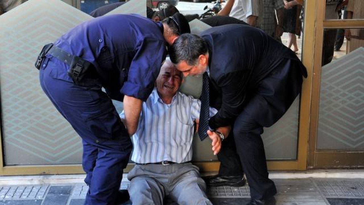 Un hombre llora en la entrada de un banco griego en Atenas.-Foto: AFP / SAKIS MITROLIDIS