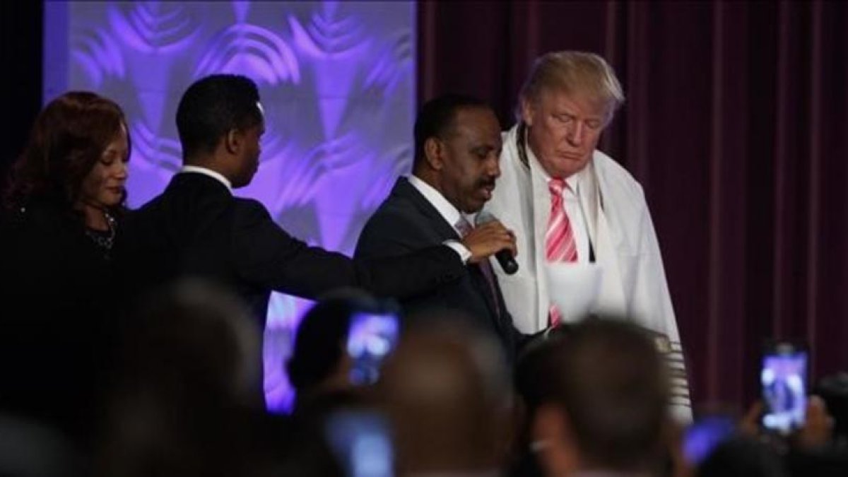 Donald Trump con una túnica de oración durante la visita a una iglesia negra en Detroit.-EVAN VUCCI / AP