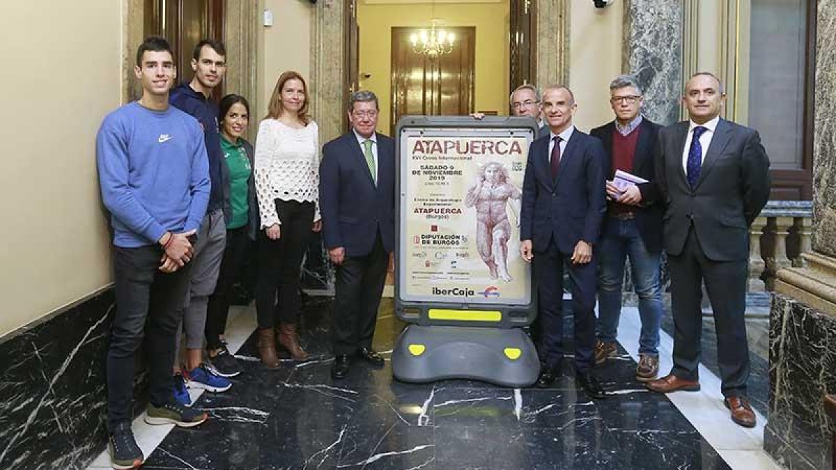 Los protagonistas de la presentación posan junto al cartel del Cross de Atapuerca.-RAÚL G. OCHOA