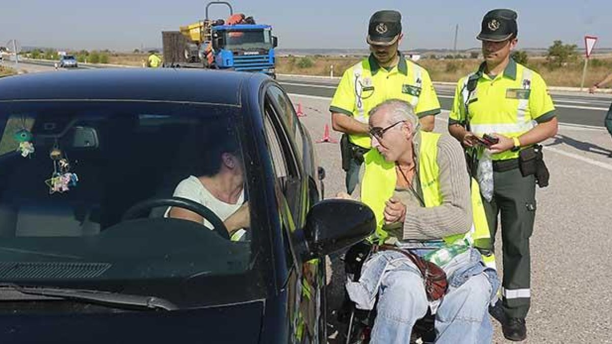 Uno de los voluntarios charla con una conductora en un control ayer en la N-120.-RAÚL G. OCHOA