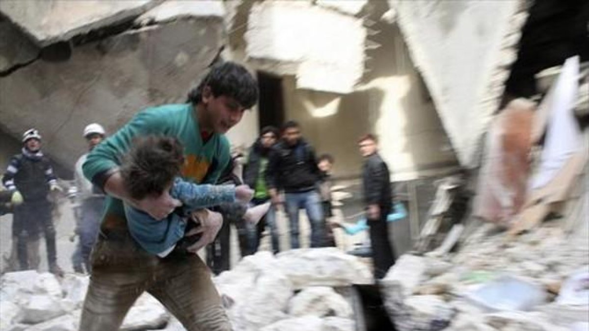 Un hombre traslada a una niña herida tras un bombardeo en Alepo.-REUTERS / Karam al Halabi