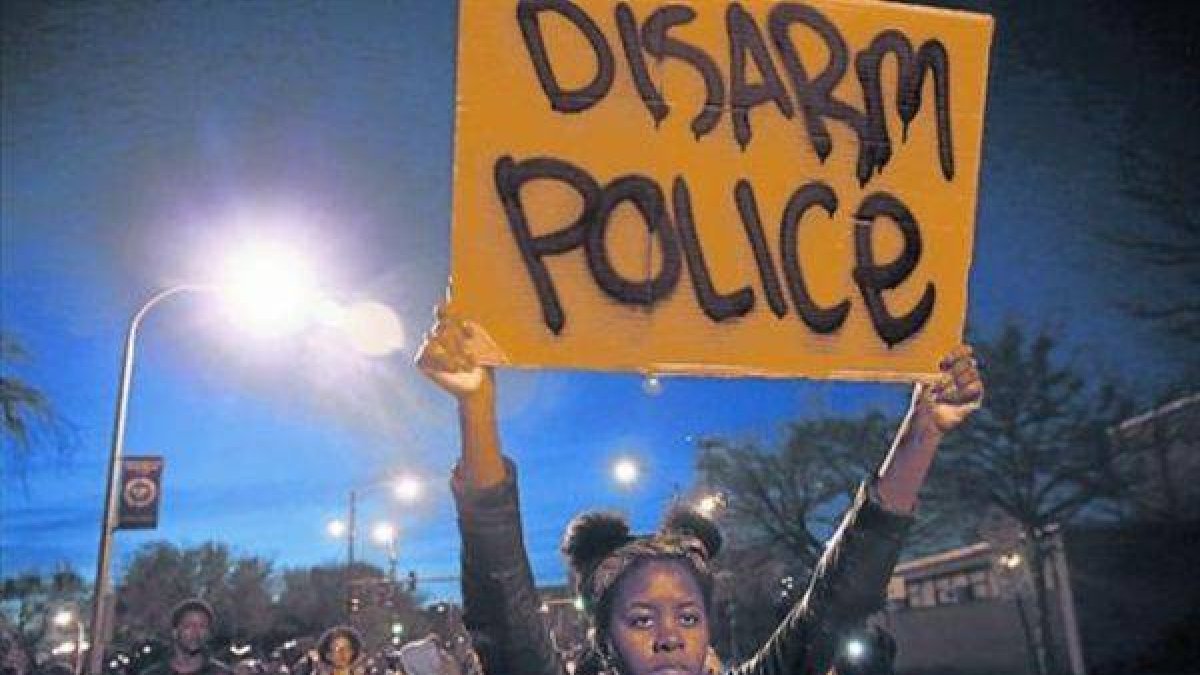 Una manifestante sostiene un cartel en una marcha solidaria con Baltimore, este miércoles en Chicago.-Foto: REUTERS / JIM YOUNG