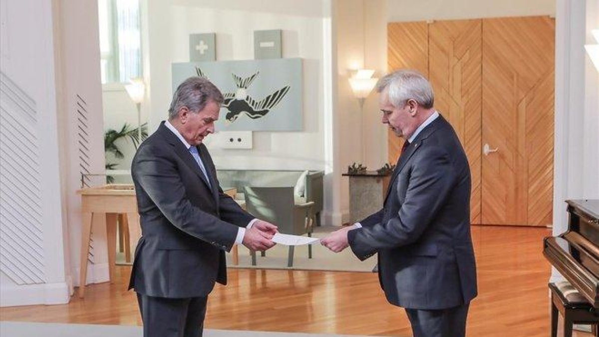 El primer ministro de Finlandia, Antti Rinne (derecha), tras su renuncia en Helsinki.-
