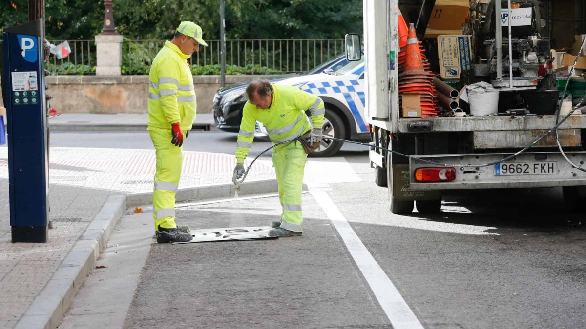 Los operarios pintan las marcas viales del aparcamiento para motos de la calle Condestable. SANTI OTERO
