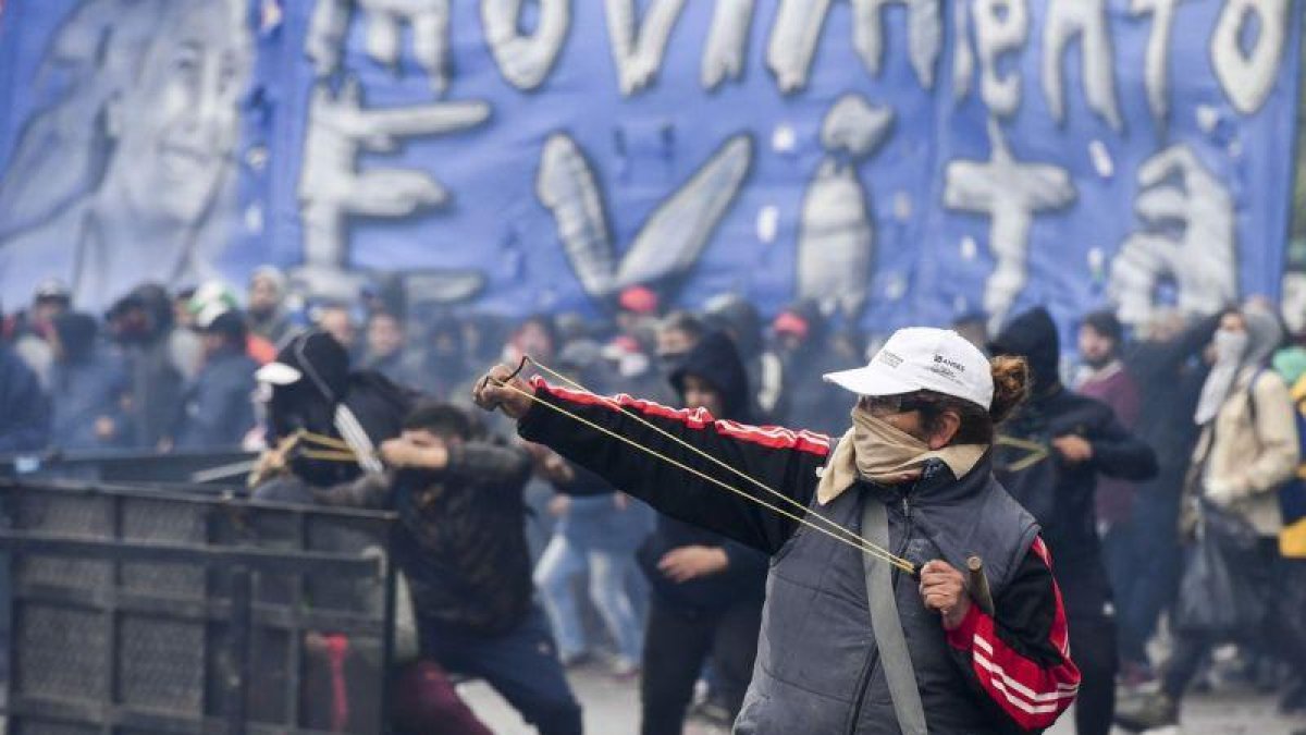 Un manifestante lanza una pieza durante las protestas en Buenos Aires por el ajuste económico aprobado por el Congreso.-AFP / EITAN ABRAMOVICH