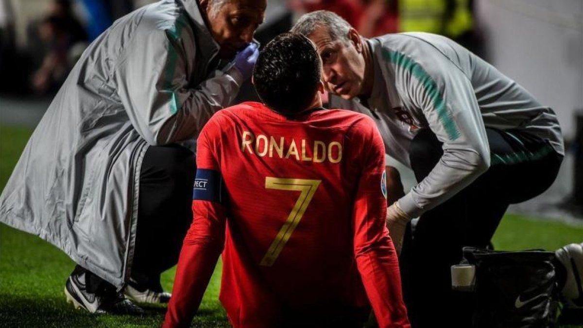Cristiano Ronaldo, atendido tras la lesión.-AFP / PATRICIA DE MELO