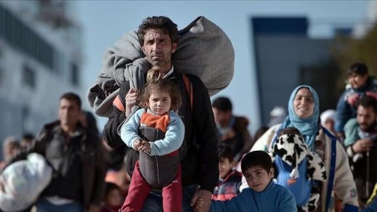 Llegada al puerto del Pireo de un grupo de inmigrantes con niños procedentes de Lesbos y Chios, el lunes.-AFP / LOUISA GOULIAMAKI