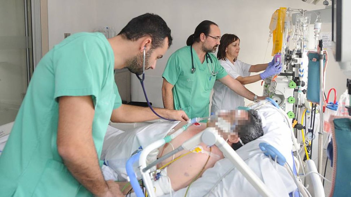 Dos médicos y una enfermera atienden a un paciente en la UCI del HUBU.-ISRAEL L. MURILLO