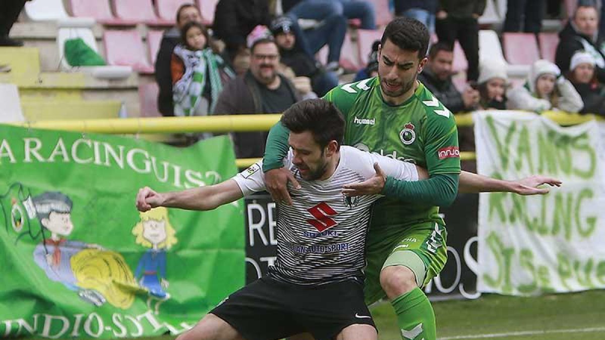 Iker Hernández protege el balón ante la presión de un jugador del Racing de Santander.-RAÚL G. OCHOA