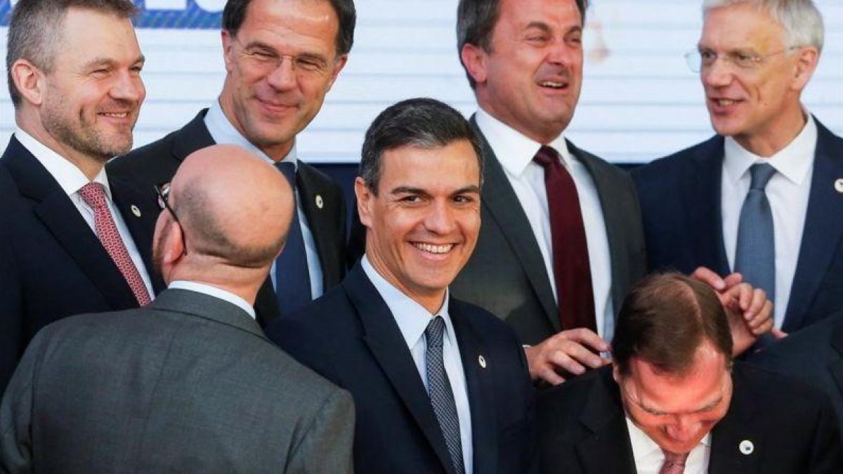 Pedro Sanchez bromea con los primeros ministros eslovaco, belga, holandés, luxemburgués, sueco y letón mientras posan en la foto de familia del Consejo Europeo, este viernes en Bruselas.-JULIEN WARNAND / EFE