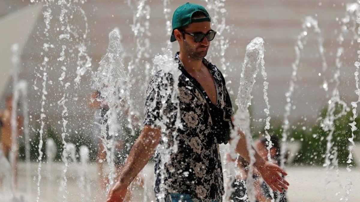 Un turista se refresca en una fuente de Lisboa.-REUTERS / RAFAEL MARCHANTE