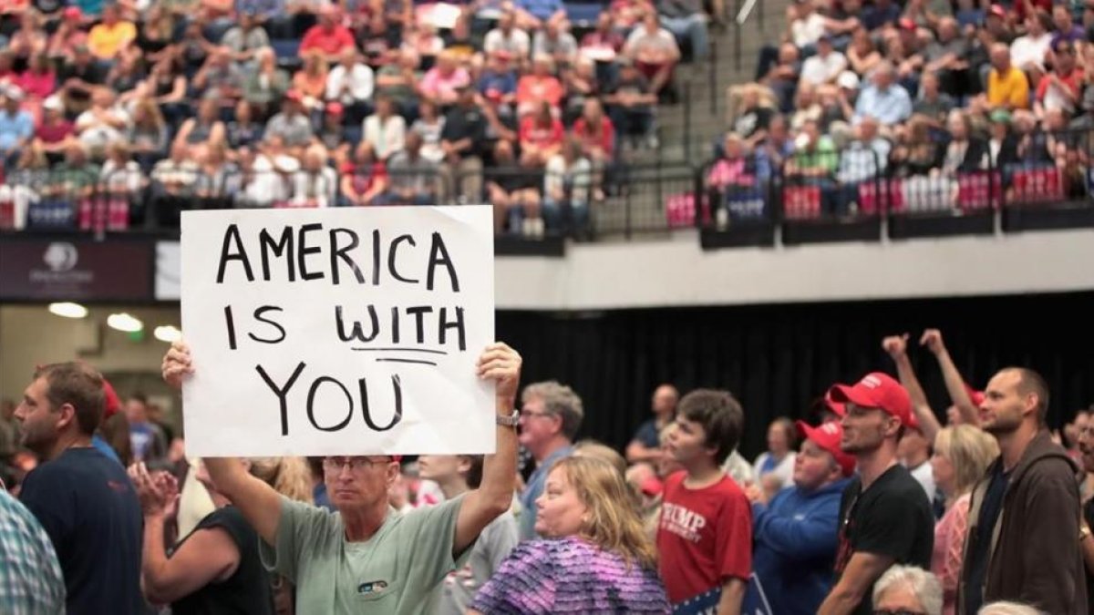 Un seguidor de Trump muestra un cartel con la frase