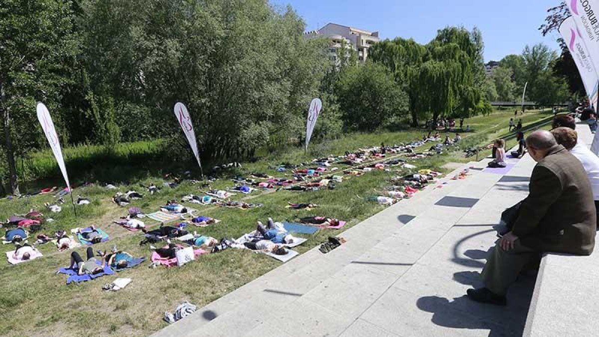 Decenas de burgaleses se sumaron a la celebración del Día Mundial del Yoga y practicaron la disciplina a orillas del Arlanzón.-RAÚL G. OCHOA