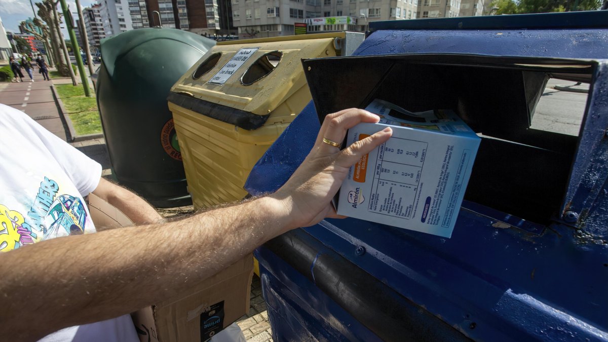 Un hombre recicla un envase de cartón. SANTI OTERO