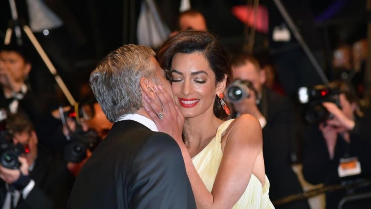 George Clooney besa a su esposa, Amal.-AFP / LOIC VENANCE