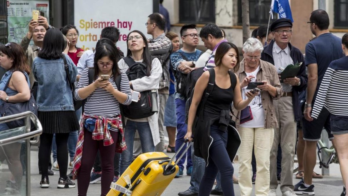 Turistas en Barcelona.-