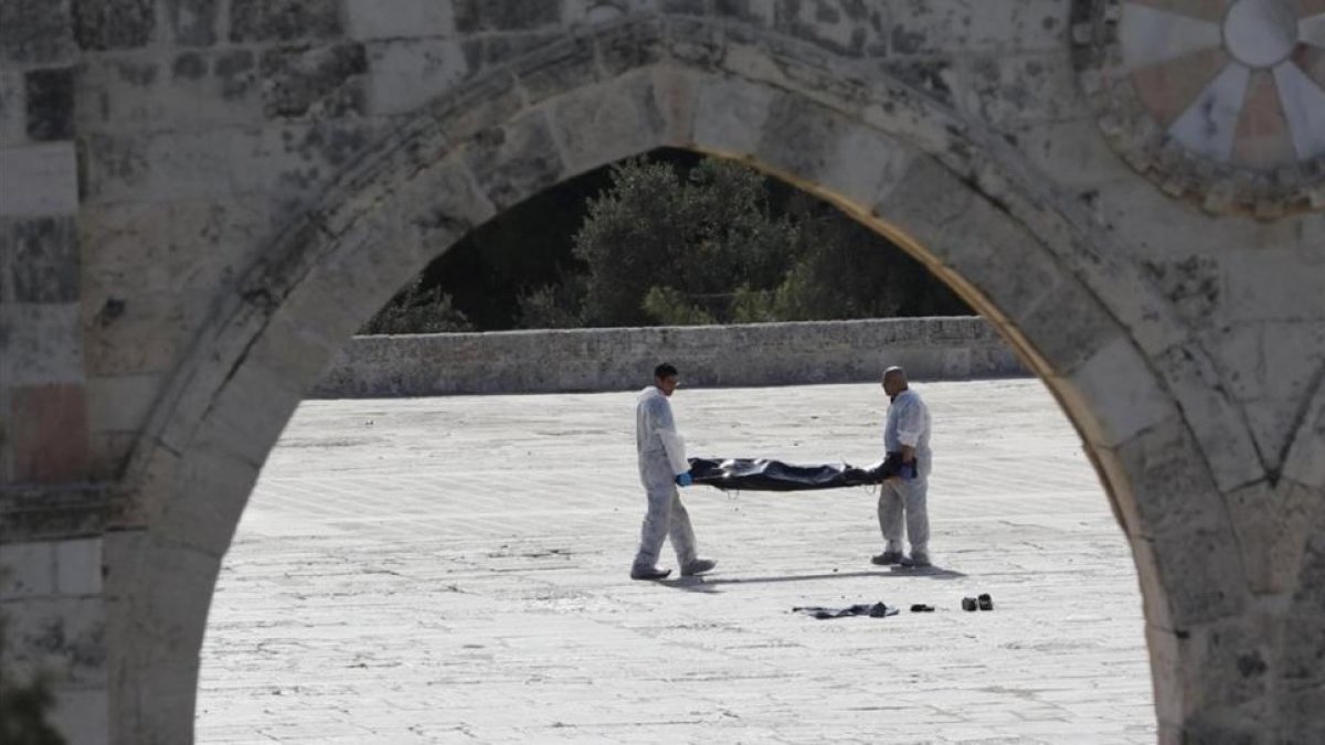 La policía israelí retira el cuerpo sin vida de un palestino.-REUTERS / AMMAR AWAD
