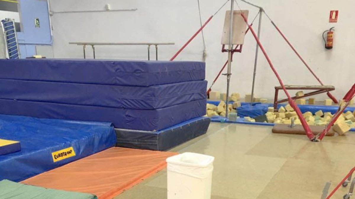 Un cubo en mitad del gimnasio para recoger las goteras.-ECB