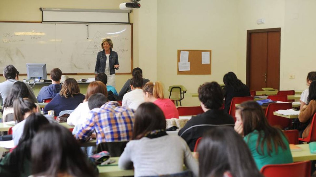 Una profesora imparte clase en un aula.-