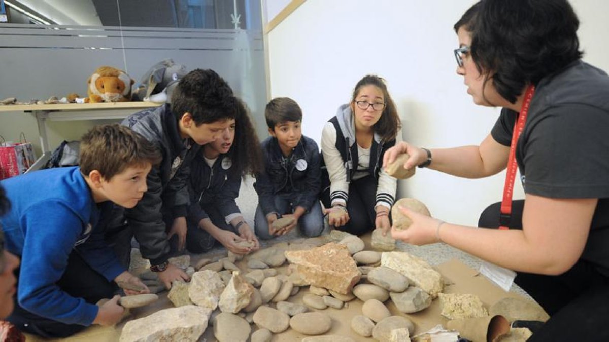 Un grupo de participantes del taller ‘Con las manos en las piedras’ escuchan atentamente las explicaciones de la monitora sobre cómo se elaboraban las herramientas.-ISRAEL L. MURILLO