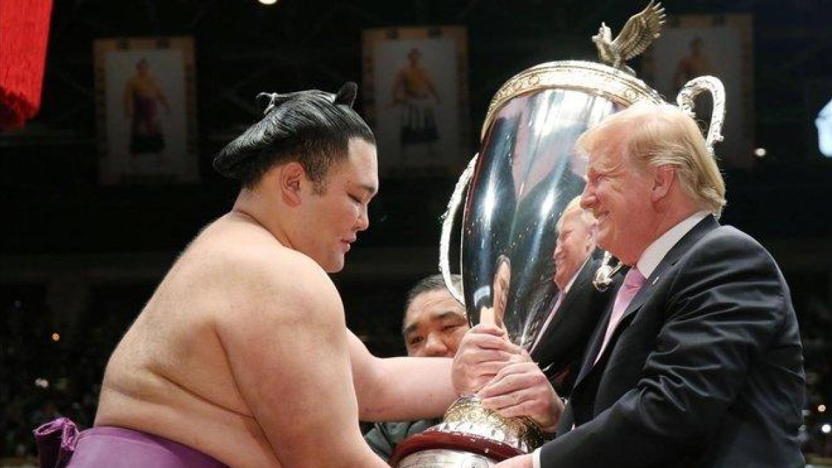 Trump recibe una copa de parte de un luchador de sumo, este domingo en Tokio.-EFE / EPA JIJI PRESS