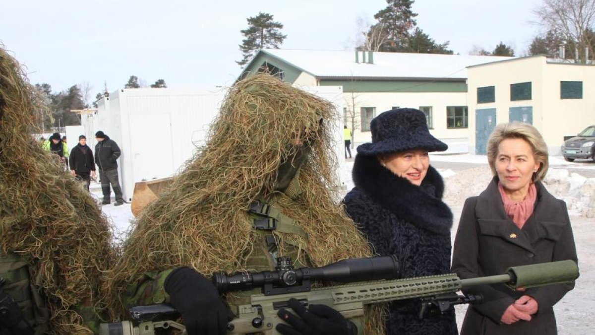 La ministra alemana de Defensa, Ursula von der Leyen (a la derecha), y la presidenta de Lituania, Dalia Grybauskaite, junto a un soldado en la ceremonia de bienvenida a las tropas de la OTAN.-PETRAS MALUKAS