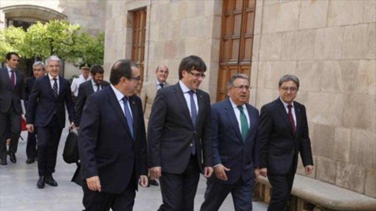 Jordi Jané, Carles Puigdemont, Juan Ignacio Zoido y Enric Millo, en el Pati dels Tarongers de la Generalitat, en julio.-JULIO CARBÓ