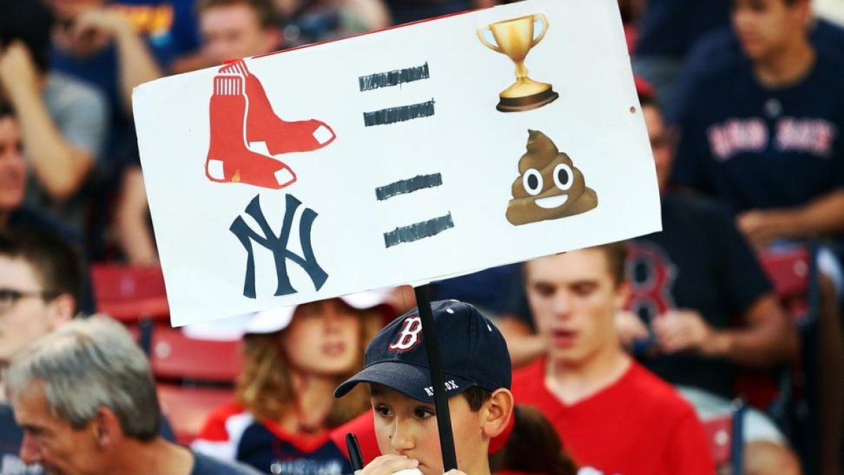 Un joven sostiene una pancarta con dibujos de 'emojis' en el partido de béisbol entre los New York Yankees y los Boston Red Sox de este domingo.-AFP