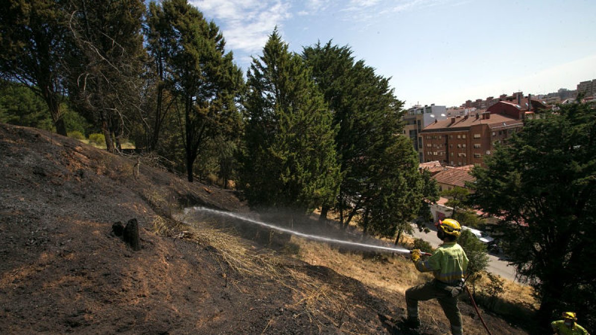 La cuadrilla de Medio Ambiente refrescó el terreno ayer por la mañana para evitar que el incendio volviera a prender avivado por el viento. FOTOS: TOMÁS ALONSO