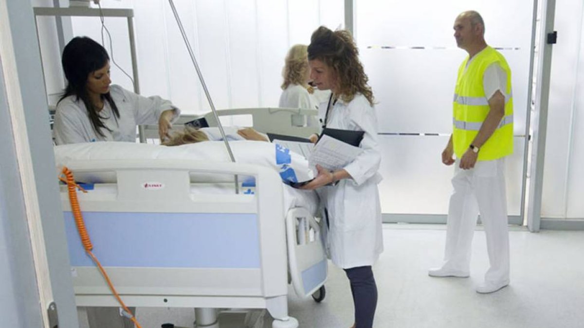 Un grupo de profesionales sanitarios atienden a uno de los ingresados en el hospital.-RAÚL G. OCHOA
