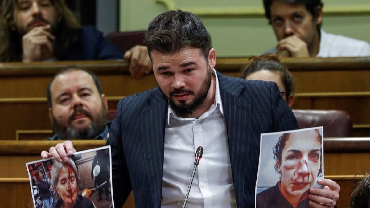 El portavoz de ERC Gabriel Rufian muestra unas fotografias durante su intervencion en la sesion de control al Gobierno hoy en el Congreso tras la declaracion y posterior suspension temporal de independencia de Cataluña-EFE/ EMILIO NARANJO