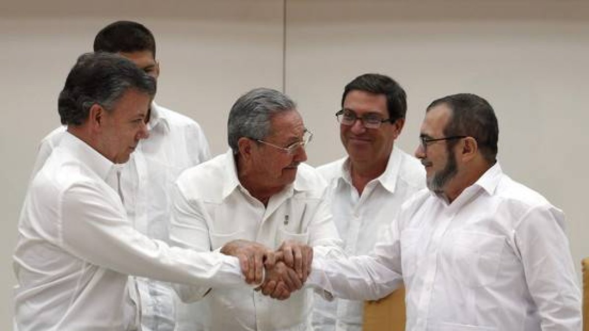 Raúl Castro sostiene las manos estrechadas del presidente de Colombia, Juan Manuel Santos, y del líder de las FARC, Rodrigo Londoño, alias 'Timochenko', este miércoles en La Habana.-EFE / ORLANDO BARRIA