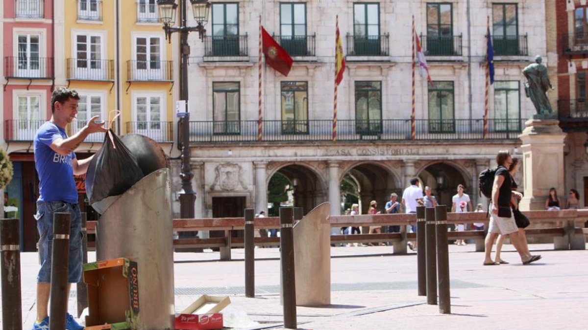Una persona deposita basura en un contenedor soterrado de la Plaza Mayor.