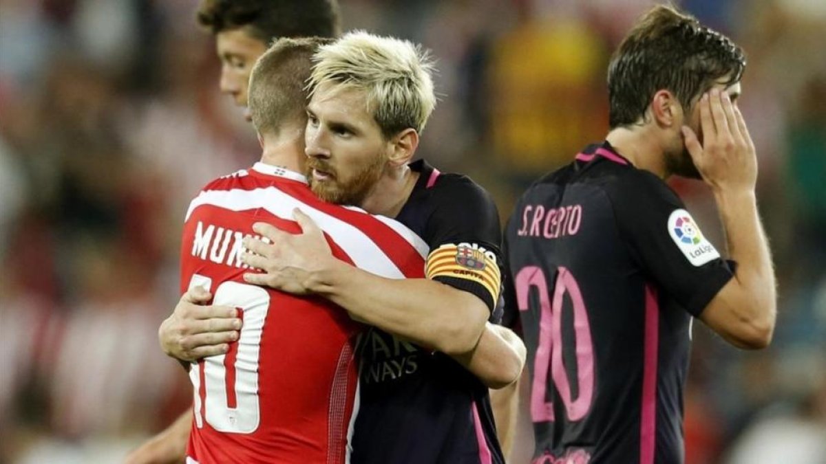 Messi se abraza a Muniain tras el partido.-LUIS TEJIDO
